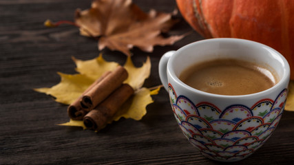 Coffee cup on autumn leaves. Space for text