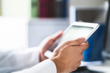 Doctor and medical professional using tablet at work in health care. Physician using digital...