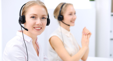 Naklejka premium Bright call center office. Two blonde women in a headset