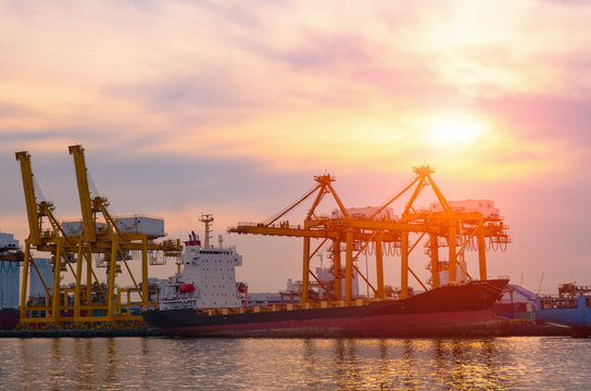 Container Cargo ship and cargo plane with working crane bridge in shipyard during sunrise,logistic import export and use for freight cargo.