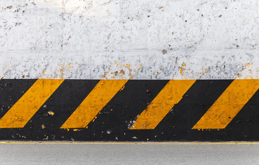 Obraz premium Concrete wall with striped caution pattern