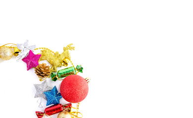 Christmas frame of decor balls, garland, beads, reindeer red pink blue golden decorations on white background. Top view.