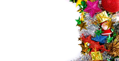 Christmas frame of decor balls, garland, beads, reindeer red pink blue golden decorations on white background. Top view.