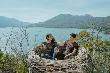 asian couple sitting on their nest on top of the hill