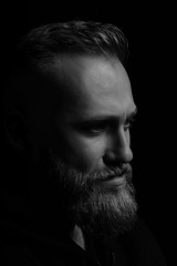 Black and white portrait of serious young man Isolated on black background and looking at camera Confident concept