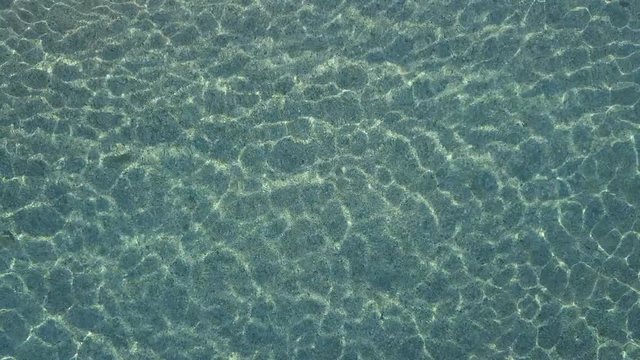 Aerial view of water reflections on the sea. Transparent water