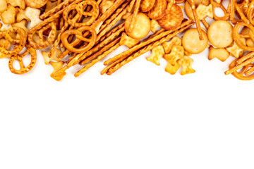 A variety of salty crackers, sticks, pretzels, and goldfishes, shot from the top on a white...