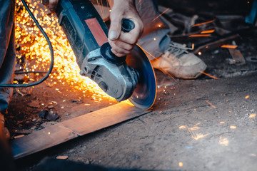 Man in industrial workshop with work tool - angle grinder