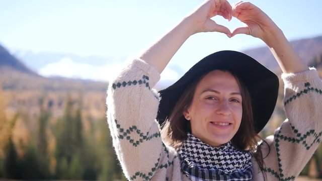 A woman with raised hands on top of a mountain looking at the view. The girl raises her hand up, noting the scenic landscape, enjoying nature, traveling adventure. Gorny Altai on the way to Mangolia