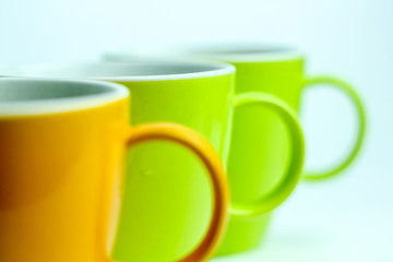 Close up Row of Colorful Mugs Isolated on a White Background