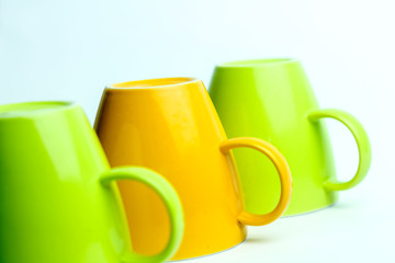 Close up Row of Colorful Mugs Isolated on a White Background