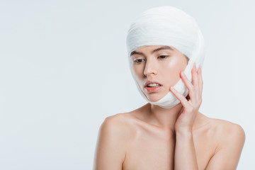 nude woman with bandages on head after plastic surgery isolated on white