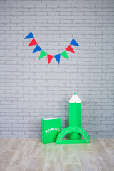 Studio shoot of school book pencil colorful flags on grey brick wall. School study decorations.On...