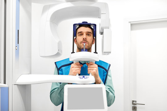 medicine, dentistry and healthcare concept - male patient having panoramic x-ray scanning procedure at dental clinic - Powered by Adobe