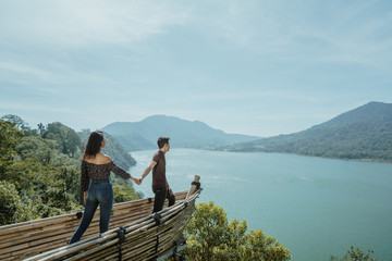 couple holding hand enjoying nature from hill top