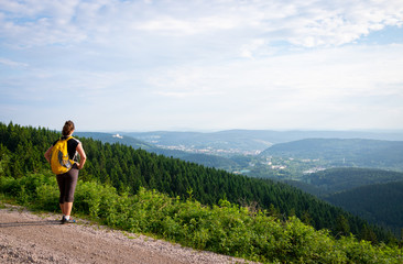 Fototapeta na wymiar Female hiker with backpack enjoying beautiful valley view in Thuringian Forest Nature Park, Germany 