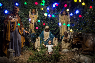 Christmas nativity scene with baby Jesus in the manger with wise men and angels and colorful...