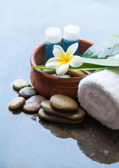 Obraz na płótnie Canvas Spa Flower on two green leaves on towel and bowl of water. Body care and spa concept