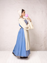 Fototapeta premium Medieval Woman in Historical Costume Wearing Corset Dress and Bonnet.