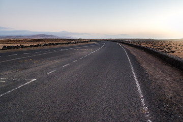 Desertic road in Fuerteventura at sunset, Spain