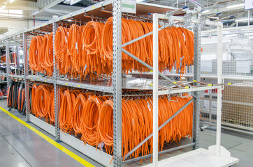 Coils of electrical wires for installation in cars, finished products on the racks in the factory....