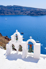 Bell tower of Orthodox church with view over volcanic caldera at Oia, Santorini Island, Greece 