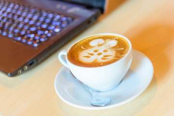 hot cappuccino coffee with cute cream rabbit pattern on table