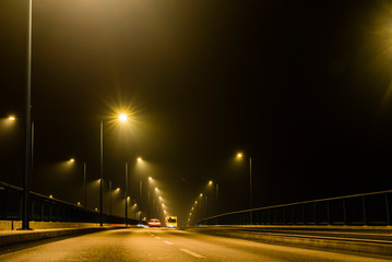 Fototapeta na wymiar Misty empty bridge at night, Foggy empty Bridge at night, wet road at night