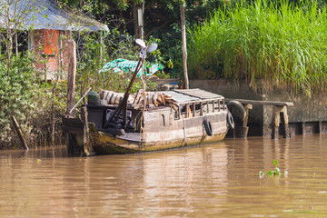 Traditional wooden vietnamese boat with added motor on the river at Mekong Delta in Cai Be District...