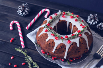 Homemade chocolate Christmas cake decorated with rosemary and pomegranate, front view