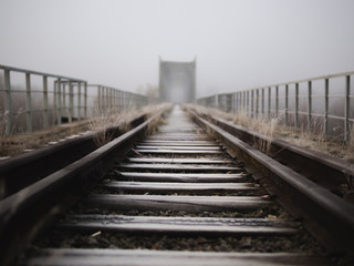 old railway bridge in the early foggy morning. terrible place