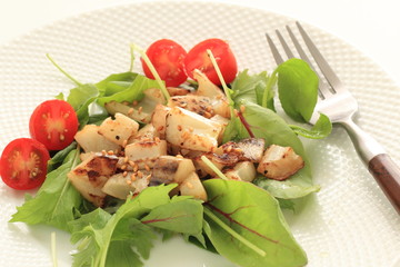 stir fried lotus root served baby leaves and cherry tomato
