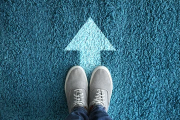 Foto op Plexiglas Man standing on carpet with arrow pointing in one direction. Concept of choice © Pixel-Shot