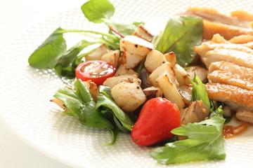 stir fried lotus root served baby leaves and cherry tomato