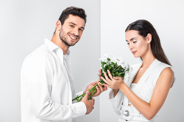 close up of adult woman gently holding bouquet while happy man smiling