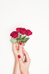 flowers roses in hands of girl, top view, little red roses on white background