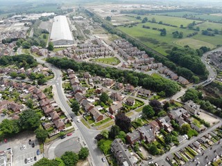 Typical UK Town aerial photo showing rows of houses, roads, parks and communal area