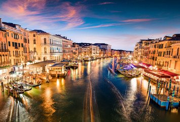 Naklejka na ściany i meble Great scene of famous Canal Grande. Colorful spring sunset from Rialto Bridge of Venice, Italy, Europe. Picturesque evening seascape of Adriatic Sea. Traveling concept background.