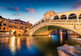 Fototapeta na wymiar Impressive sunset on famous Canal Grande. Colorful spring view of Rialto Bridge. Picturesque evening cityscape of Venice, Italy, Europe. Traveling concept background.