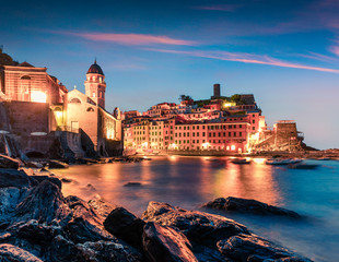 One of the five towns that make up the Cinque Terre region - Vernazza. Colorful spring sunrise in Liguria, Italy, Europe. Picturesqie seascape of Mediterranean sea. Traveling concept background.