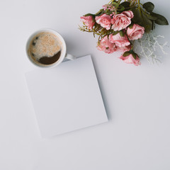 Creative winter natural composition with flowers and coffe cup. Flat lay, table top view. Greeting card copy space.