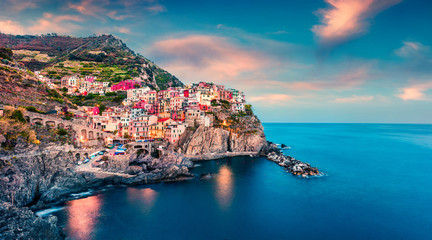 Second city of the Cique Terre sequence of hill cities - Manarola. Colorful spring sunset in...