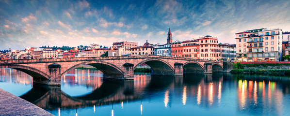 Picturesque medieval arched Ponte alla Carraia bridge over Arno river. Colorful spring sunset in...