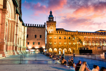 Colorful spring sunset on the main square of City of Bologna with Palazzo d'Accursio and facade of Basilica di San Petronio. Great cityscape of Bologna, Italy, Europe. Traveling concept background. - obrazy, fototapety, plakaty