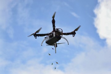 Drone throwing down colorful bonbons for kids within festival