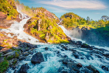 Great sunny view of Latefoss waterfall, located in the municipality of Odda in Hordaland County. Amazing summer scene in Norway. Beauty of nature concept background.