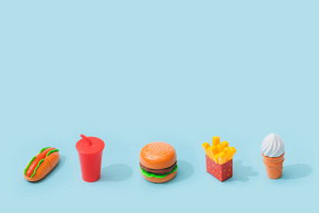 Fast food items on pastel blue background. Junk food minimal concept.