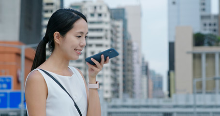 Woman speak to cellphone in city