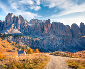 Small church on the top of Gardena pass with Piz Boe mountain on background. Colorful autumn scene in the Dolomite Alps, Canazei, Province of Trento, Italy, Europe. 