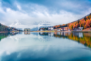 Foggy morning scene of Misurina lake in National Park Tre Cime di Lavaredo. Fantastic autumn landscape in Dolomite Alps, South Tyrol, Location Auronzo, Italy, Europe. Traveling concept background.